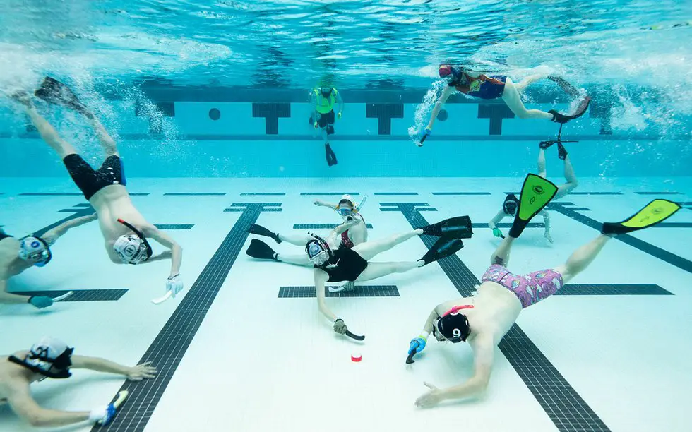 People playing Underwater Hockey in a swimming pool